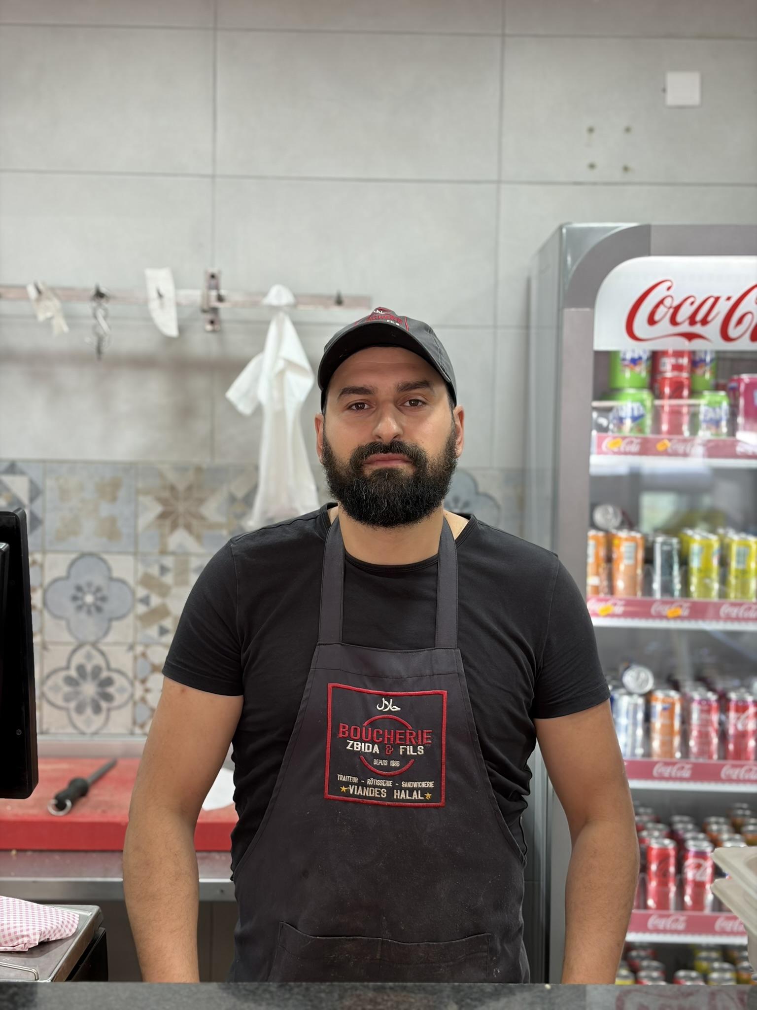 Younes Zbida, boucher, derrière le comptoir de la Boucherie Zbida & Fils